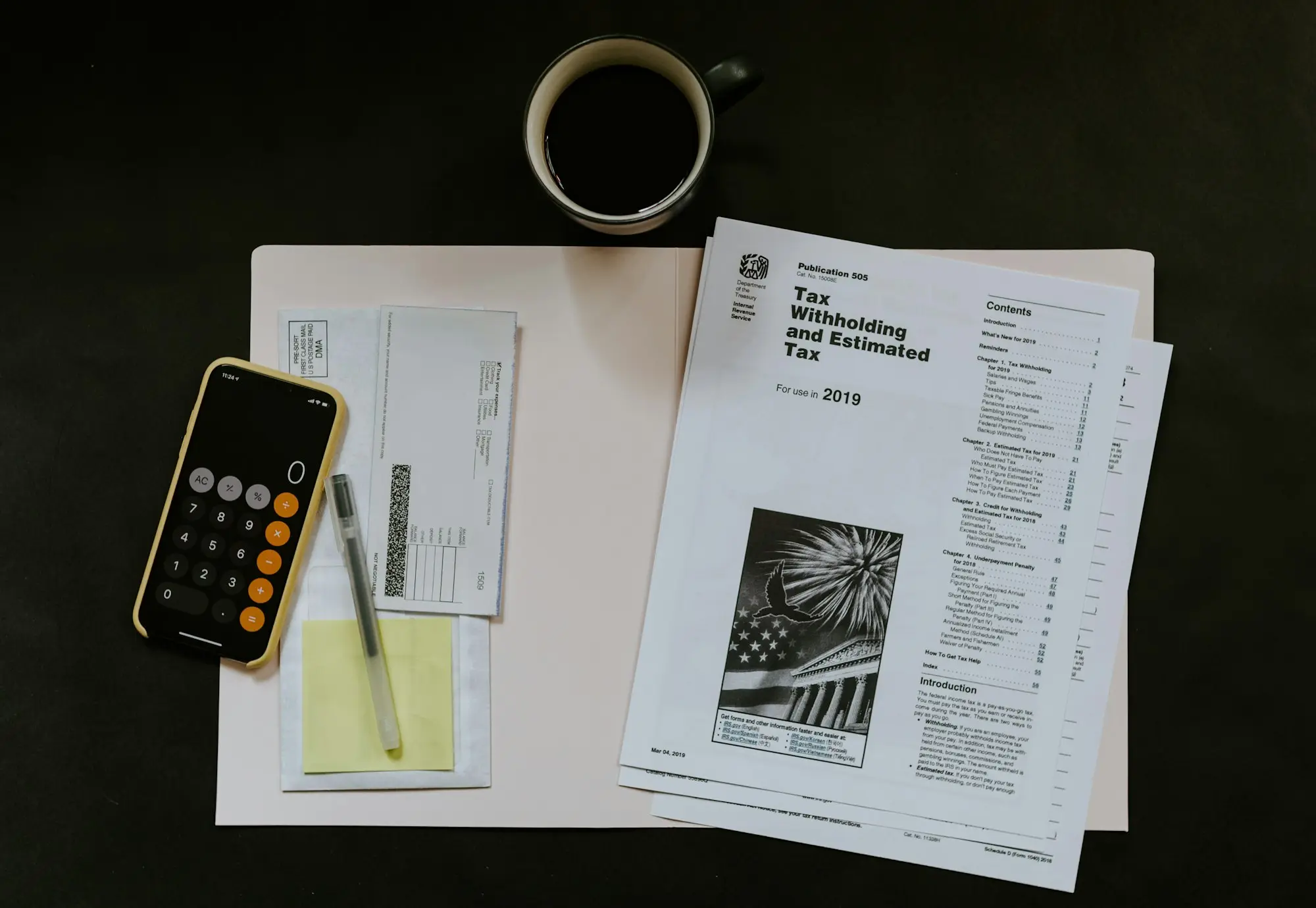 BAS paperwork, calculator and coffee on a desk