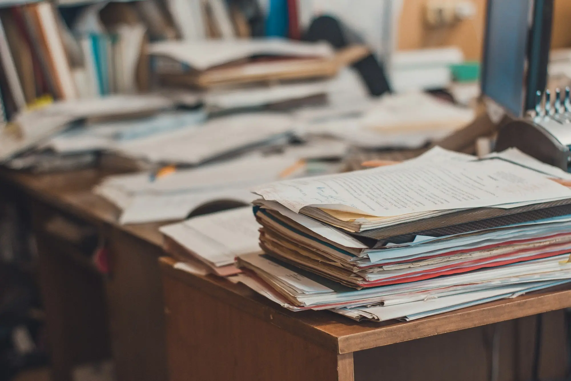 Desk piled with receipts and folders at the end of the financial year